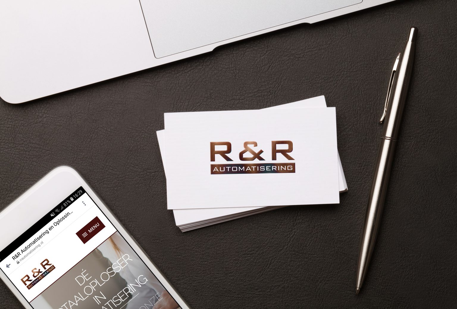 Werkplek met R&R Automatisering visitekaartjes, laptop en pen